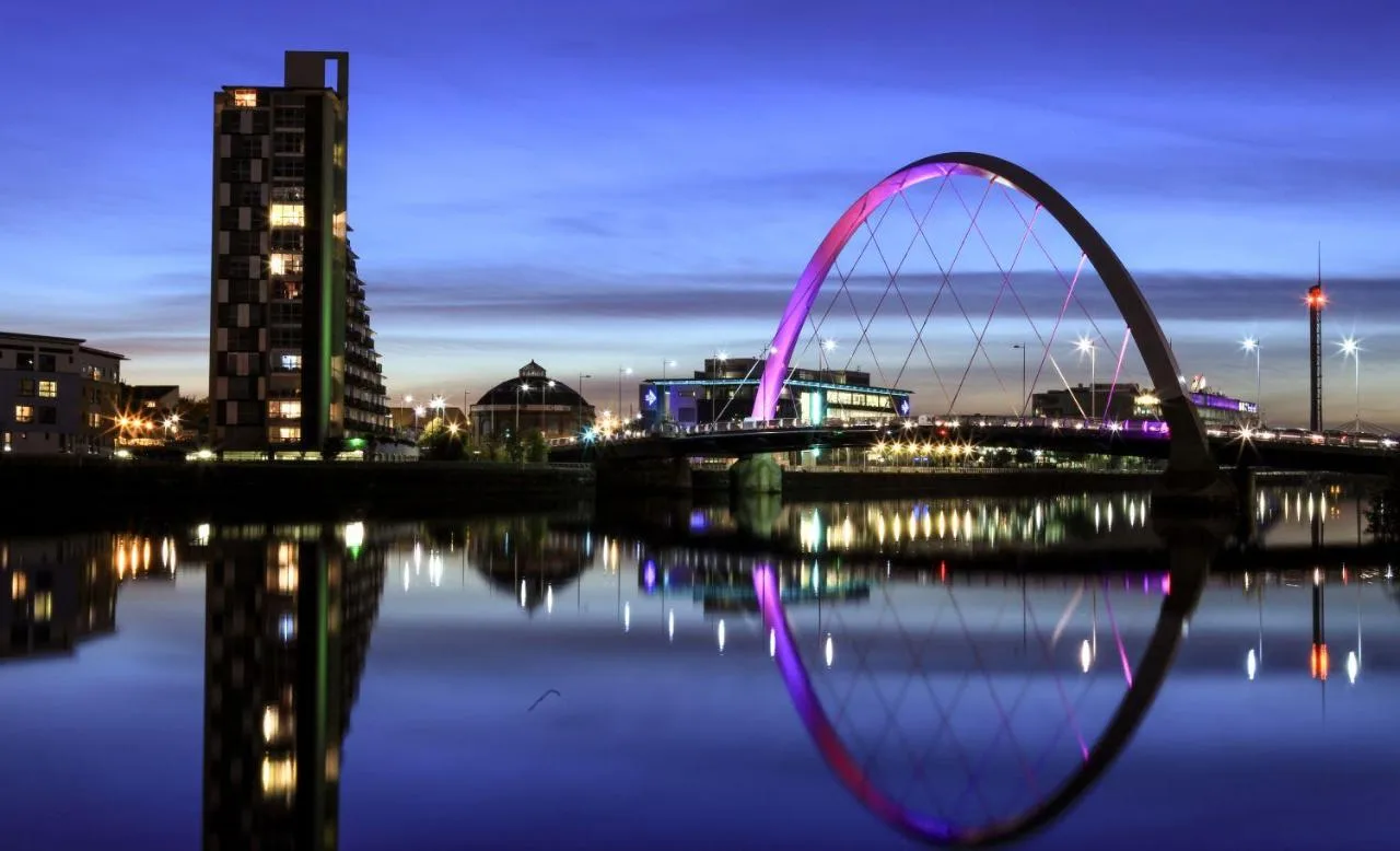 a bridge over a body of water at night at Maldron Hotel Glasgow City in Glasgow